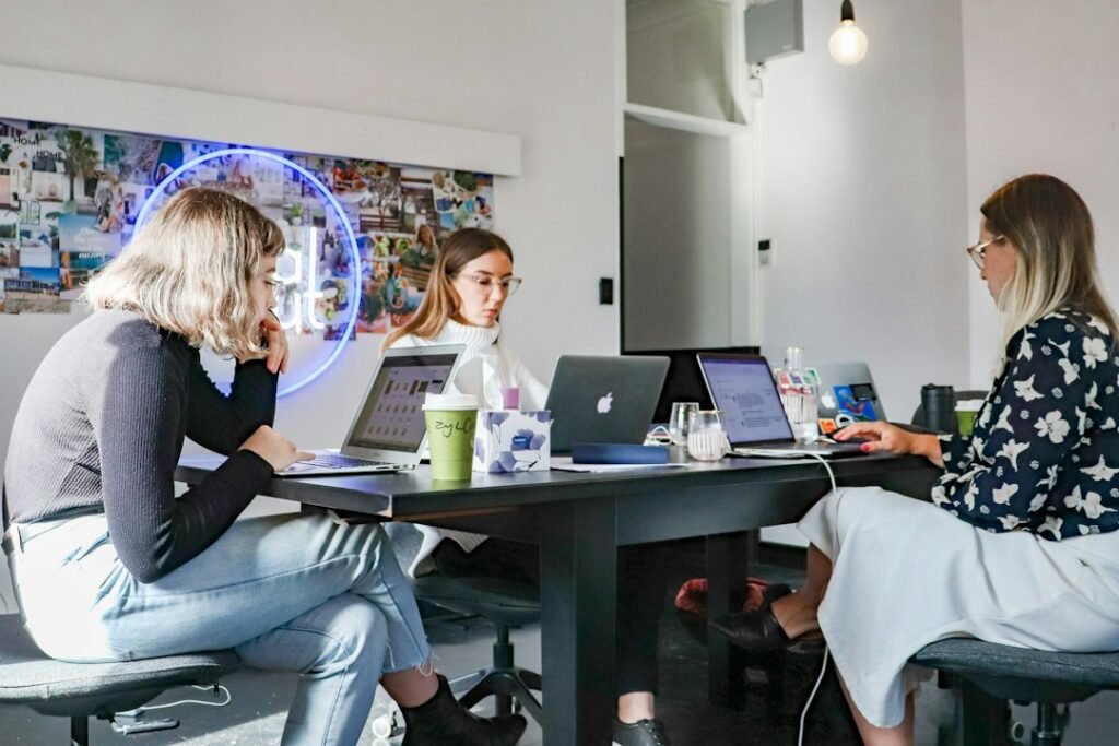 Digital marketing team working together on laptops at a table